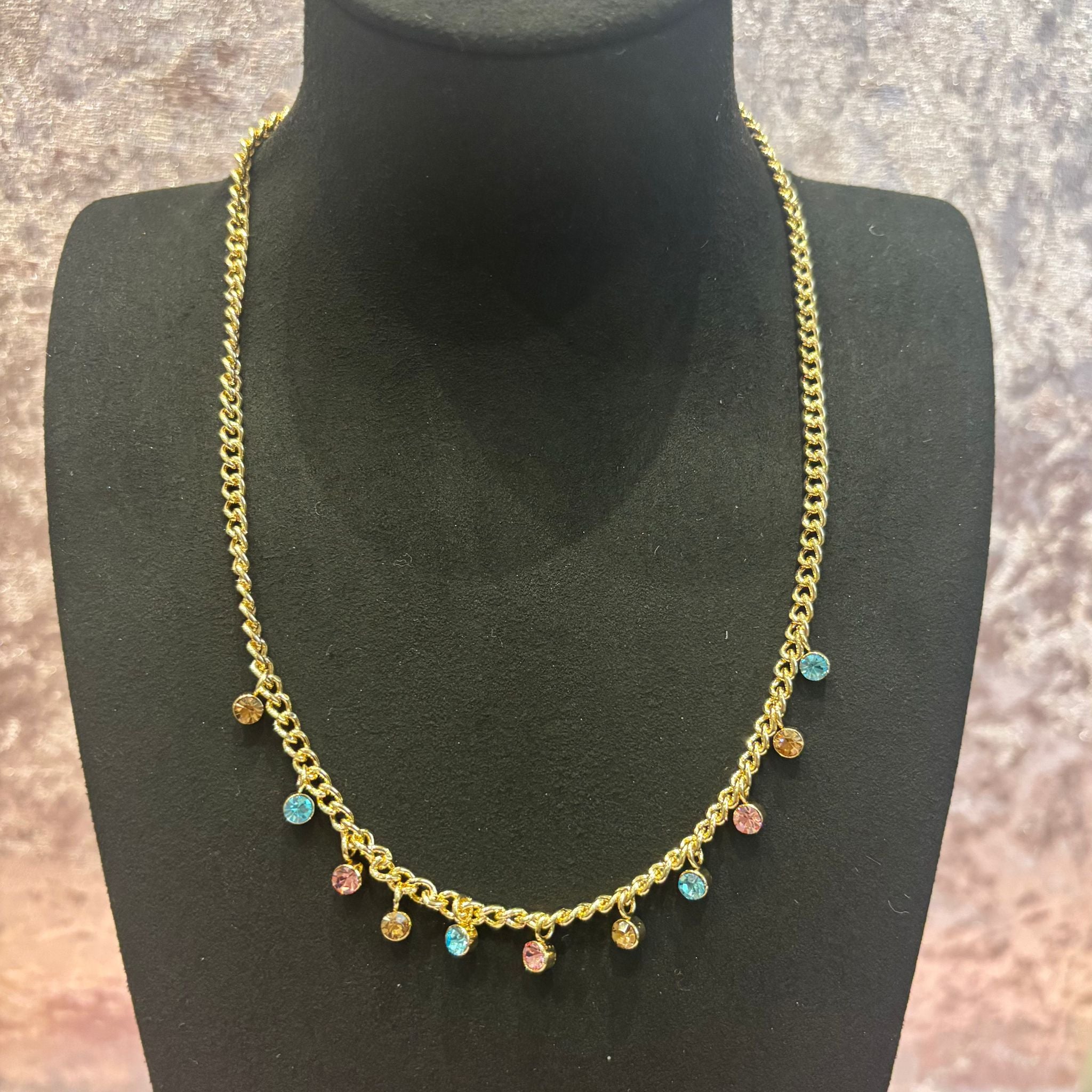 gold necklace with pink, blue, and gold diamante stones